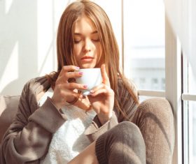 Girl with coffee cup at the front of the window Stock Photo