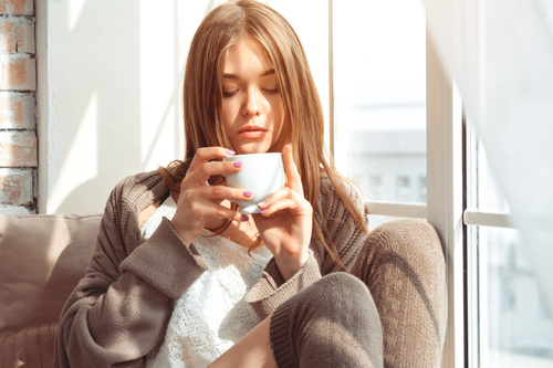 Girl with coffee cup at the front of the window Stock Photo