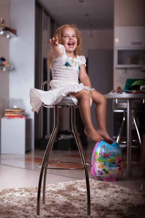 Happy little girl sitting on a metal chair Stock Photo