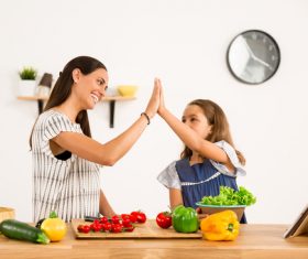 Happy mother and daughter in the kitchen clap Stock Photo