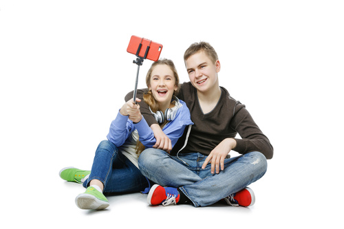 Happy teen boy and girl using a smartphone selfie Stock Photo 02
