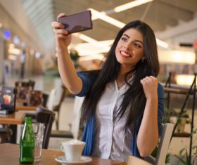 Lady using a smartphone to take selfie Stock Photo