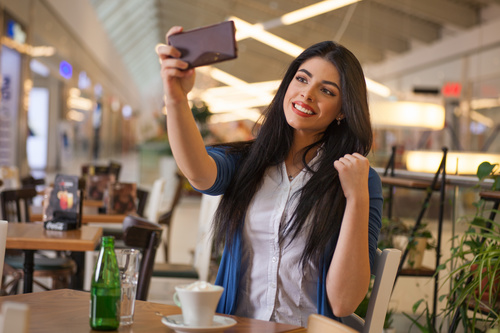 Lady using a smartphone to take selfie Stock Photo