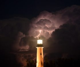 Lighthouse and lightning in cumulonimbus Stock Photo