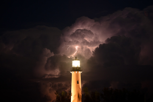 Lighthouse and lightning in cumulonimbus Stock Photo
