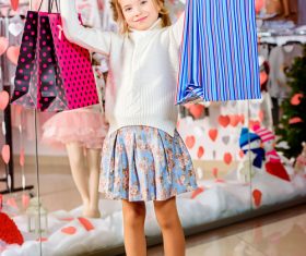Little girl posing holding a shopping bag in front of the mirror Stock Photo 02