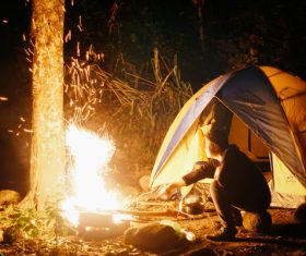 Man camping ignites campfire Stock Photo