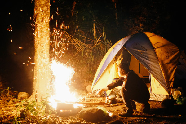 Man camping ignites campfire Stock Photo