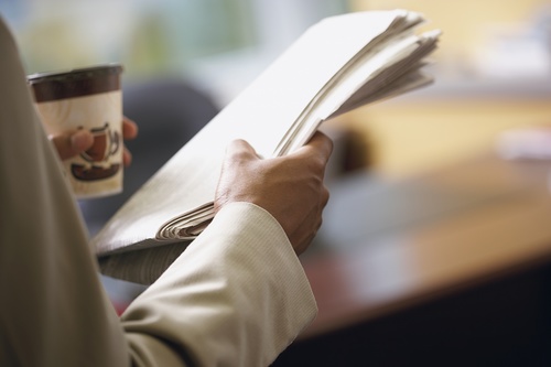 Man drinking coffee and reading newspaper Stock Photo