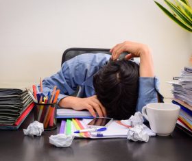 Man lying on the desk resting Stock Photo