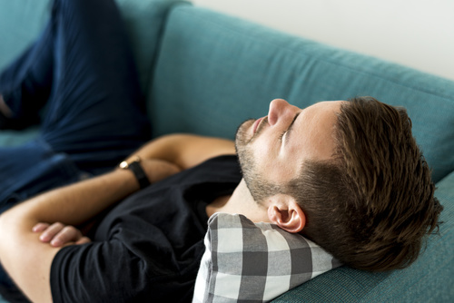 Man lying on the sofa to rest Stock Photo