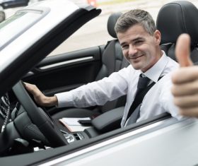 Man sitting in the car with thumbs up Stock Photo