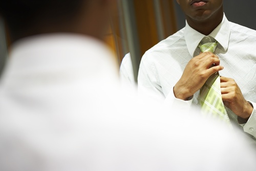 Man with a tie in front of the mirror Stock Photo