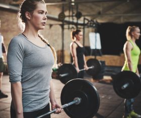 Men and women doing barbell exercises in the gym Stock Photo 01