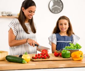 Mom teach her daughter cutting vegetables in the kitchen Stock Photo 02