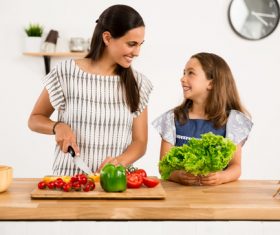 Mom teach her daughter cutting vegetables in the kitchen Stock Photo 03