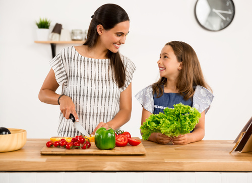 Mom teach her daughter cutting vegetables in the kitchen Stock Photo 03