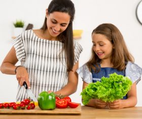 Mom teach her daughter cutting vegetables in the kitchen Stock Photo 04