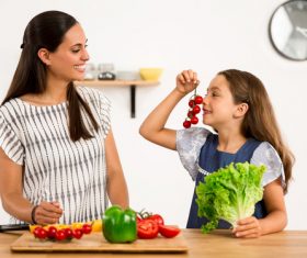 Mom teaches daughter to know vegetables Stock Photo