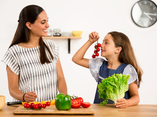 Mom teaches daughter to know vegetables Stock Photo