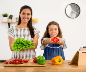 Mother and daughter holding fresh vegetables Stock Photo