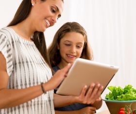 Mother and daughter watch video learn how to cook Stock Photo 01
