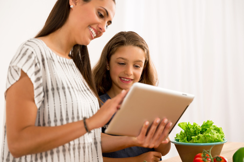 Mother and daughter watch video learn how to cook Stock Photo 01