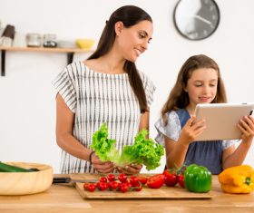 Mother and daughter watch video learn how to cook Stock Photo 02