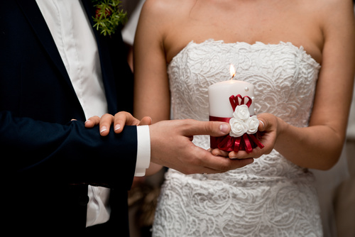 Newlyweds holding candles in hand Stock Photo