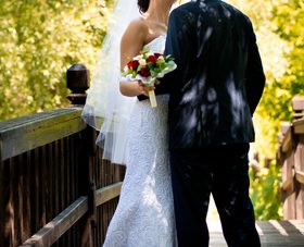 Newlyweds standing on bridge and taking wedding photographs Stock Photo 01