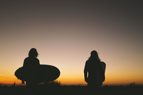 People carrying surfboard in dark dusk Stock Photo