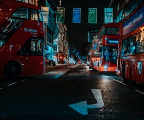 Red buses on urban city at night Stock Photo