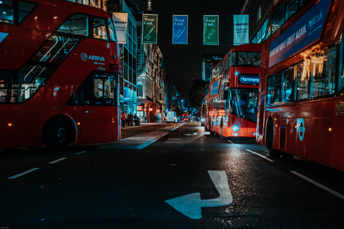 Red buses on urban city at night Stock Photo