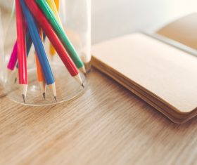 Sharp pencils and a notebook on a table Stock Photo
