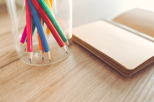 Sharp pencils and a notebook on a table Stock Photo