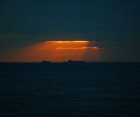 Ships on calm sea at dusk Stock Photo