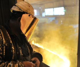 Steel workers view molten iron Stock Photo