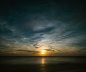 Sunlight on calm beach at dusk Stock Photo