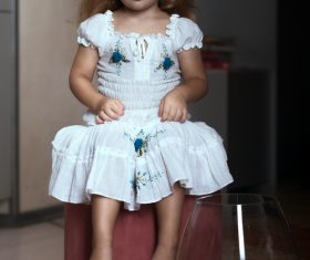 Super cute little girl sitting in chair Stock Photo