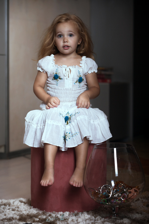 Super cute little girl sitting in chair Stock Photo