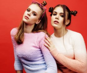 Two fashion hairstyle girls taking pictures in the studio Stock Photo 04