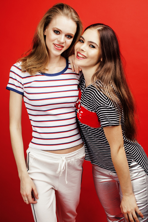 Two girls posing with red background Stock Photo 02