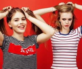 Two girls with fiddling hair take pictures in the studio Stock Photo 02