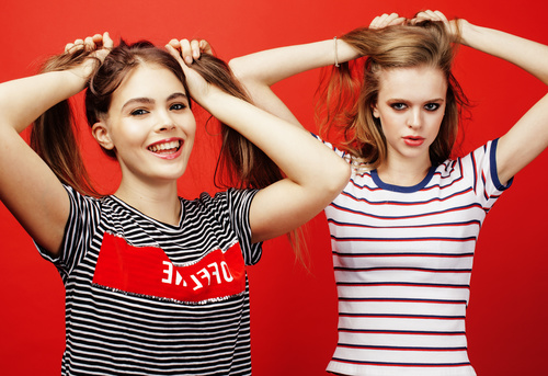 Two girls with fiddling hair take pictures in the studio Stock Photo 02