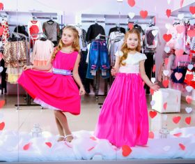Two little girls try on clothes in front of the mall mirror Stock Photo