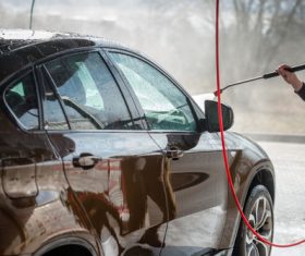 Use high pressure water gun to clean the car Stock Photo