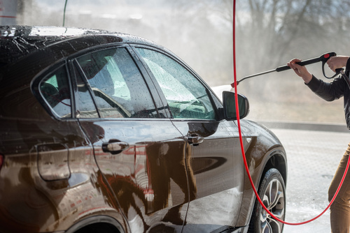 Use high pressure water gun to clean the car Stock Photo