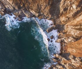 Wavy beach beside high rocky mountain Stock Photo