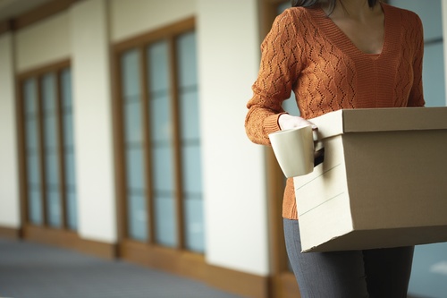 Woman holding carton box and mug Stock Photo