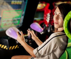 Woman playing shooting game in playroom Stock Photo